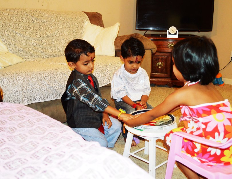 Tisha tying Rakhi on his brother wrist